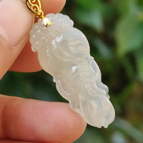 Una mano sosteniendo un colgante de jade.