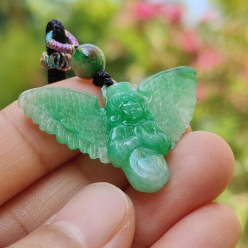 a hand holding a green stone angel