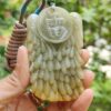 Una mano sosteniendo un colgante de jade.
