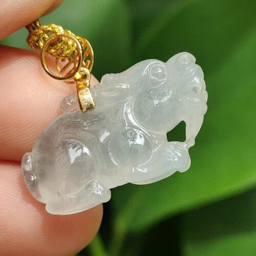 một bàn tay cầm một mặt dây chuyền ngọc bích