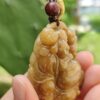 Una mano sosteniendo un colgante de jade.