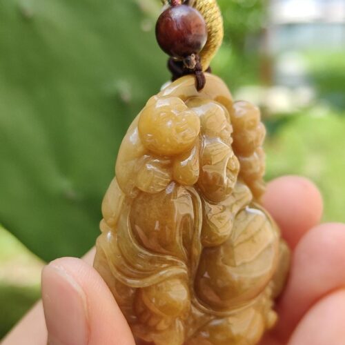 Una mano sosteniendo un colgante de jade.