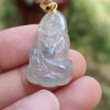 Una mano sosteniendo un colgante de jade.
