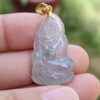 Una mano sosteniendo un colgante de jade.