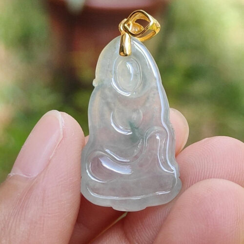 Una mano sosteniendo un colgante de jade.