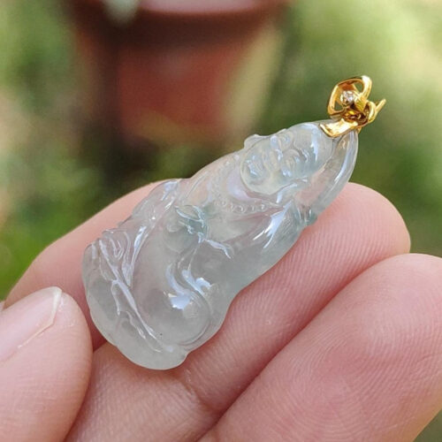 Una mano sosteniendo un colgante de jade.