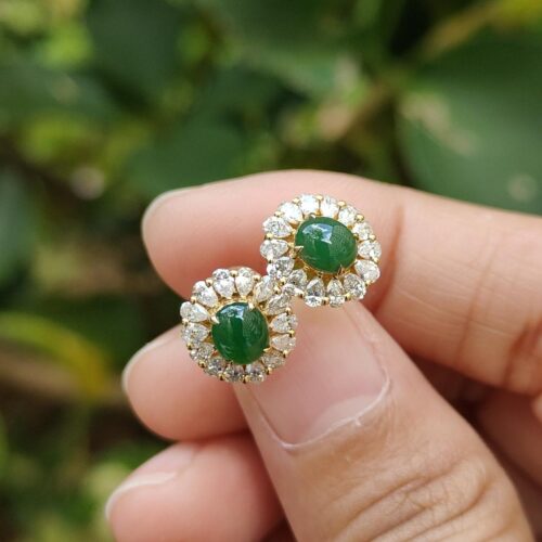 ஒரு ஜோடி காதணிகளை வைத்திருக்கும் ஒரு கை