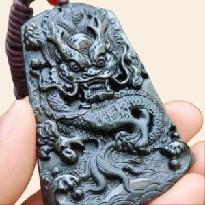 a hand holding a jade pendant