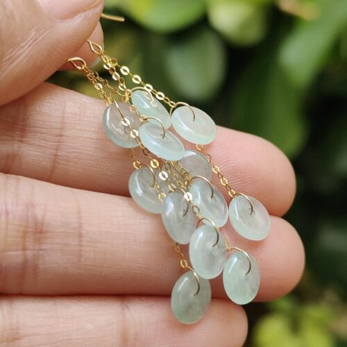 a hand holding a pair of earrings