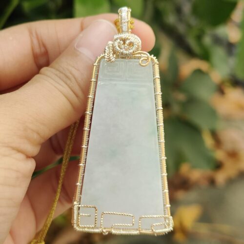 une main tenant un pendentif