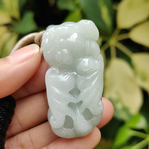 एक हाथ में जेड पेंडेंट थामे हुए