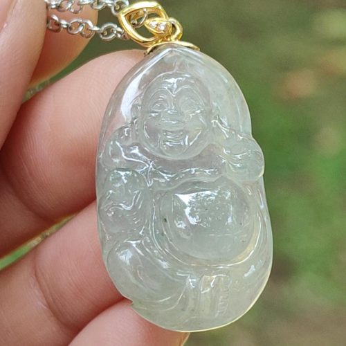 a hand holding a jade pendant