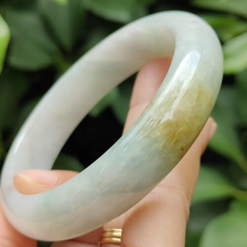 a hand holding a jade bracelet