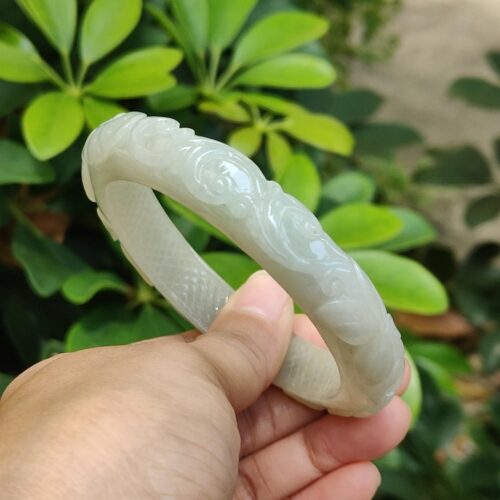 a hand holding a jade bracelet