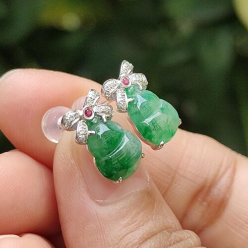 a hand holding a pair of earrings