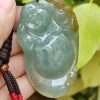 a hand holding a jade pendant