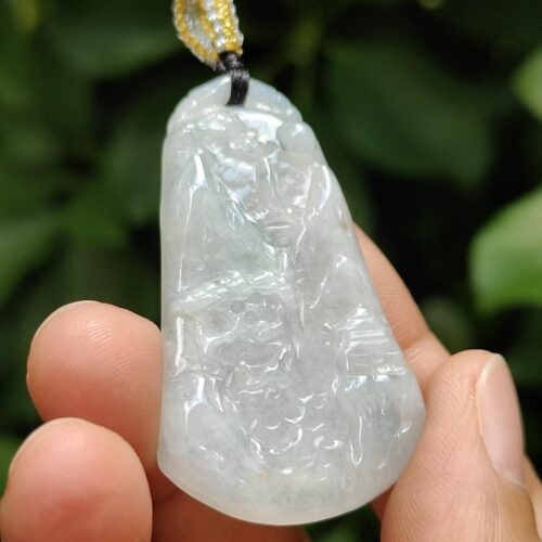 une main tenant un pendentif en jade