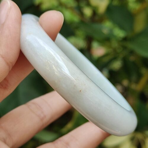 ஒரு வெள்ளை மோதிரத்தை வைத்திருக்கும் ஒரு கை