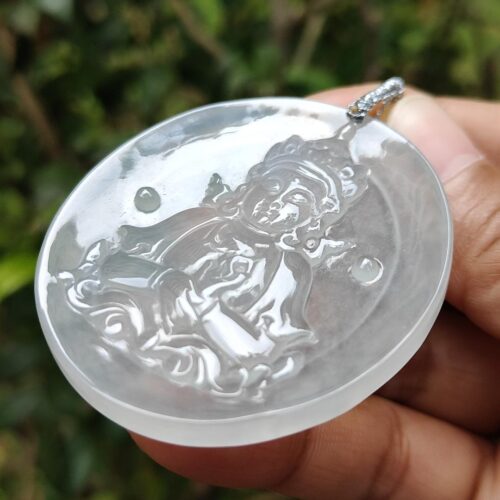 a hand holding a round white pendant