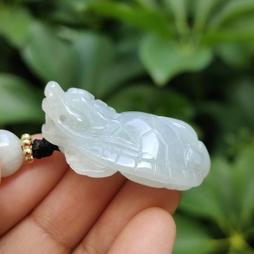 tangan memegang liontin giok