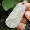 Una mano sosteniendo un colgante de jade.