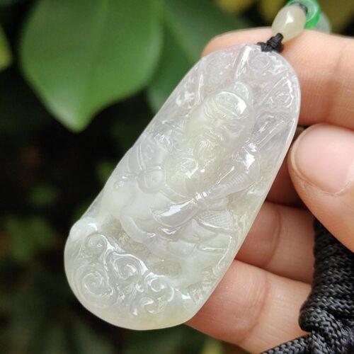 Una mano sosteniendo un colgante de jade.