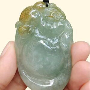 a hand holding a jade pendant