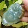 a hand holding a jade pendant