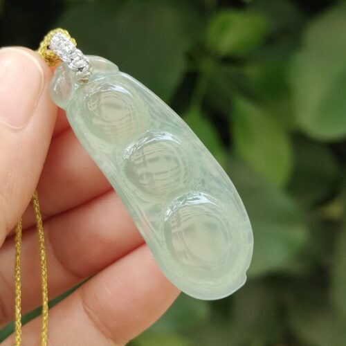 ஜேட் நெக்லஸை வைத்திருக்கும் ஒரு கை