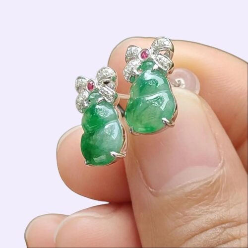 a person holding a pair of earrings