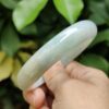 a hand holding a jade bracelet