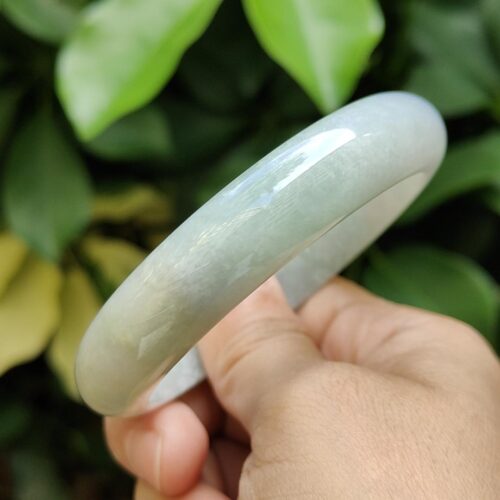 a hand holding a jade bracelet