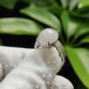 a hand wearing a glove with a white ring with a large stone