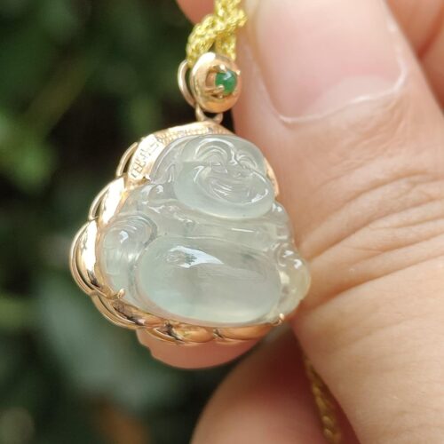 a hand holding a jade pendant