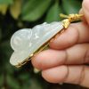 a hand holding a jade pendant