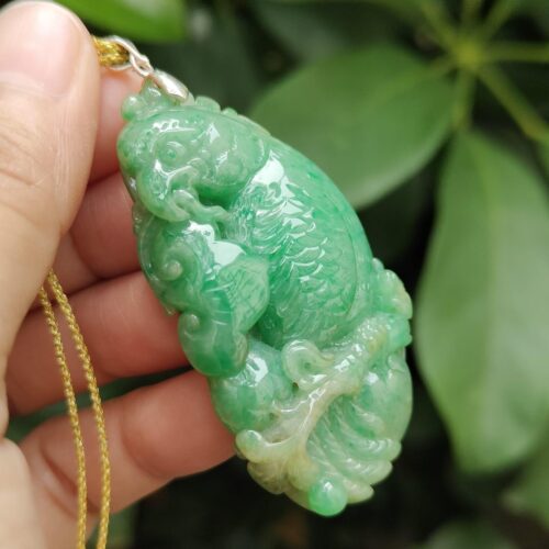 翡翠のペンダントを持つ手
