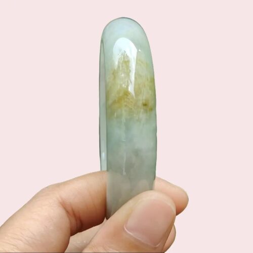 a hand holding a green and white object