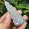 a hand holding a jade pendant