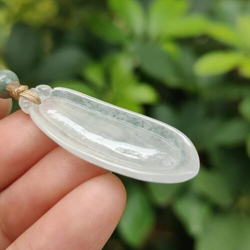 ஜேட் நெக்லஸை வைத்திருக்கும் ஒரு கை