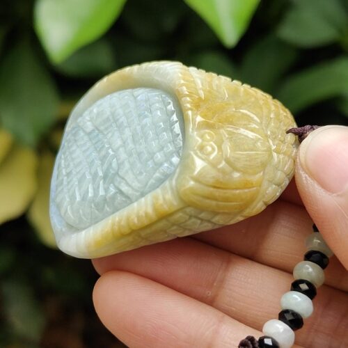 a hand holding a jade necklace