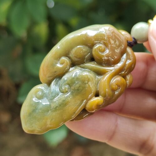 une main tenant un collier de jade