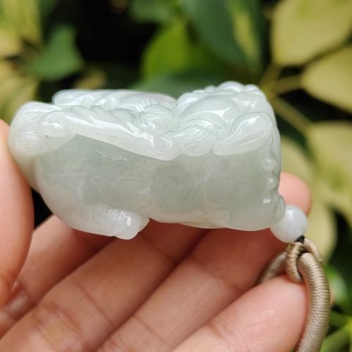 एक हाथ में जेड पेंडेंट थामे हुए