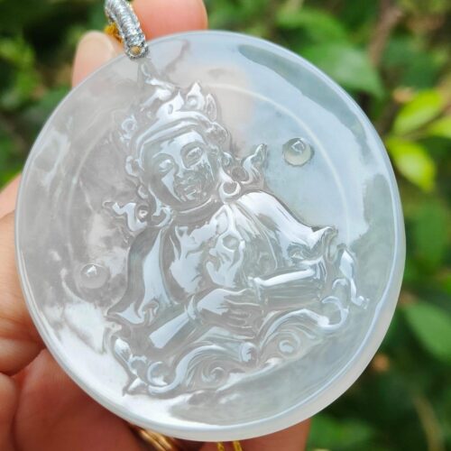 a hand holding a round white object with a person holding a gold chain