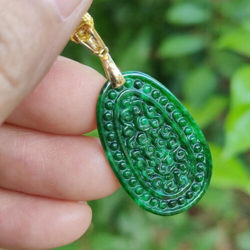 a hand holding a green pendant