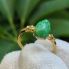 a gold ring with a green stone on it