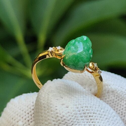 a gold ring with a green stone on it