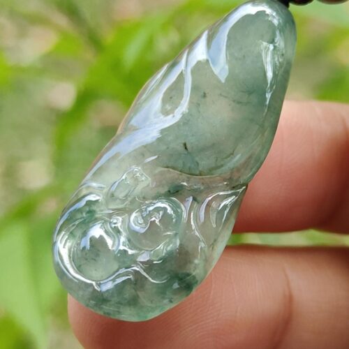 tangan memegang liontin giok