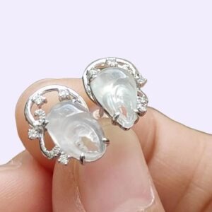 a person holding a pair of earrings