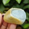 a hand holding a jade object