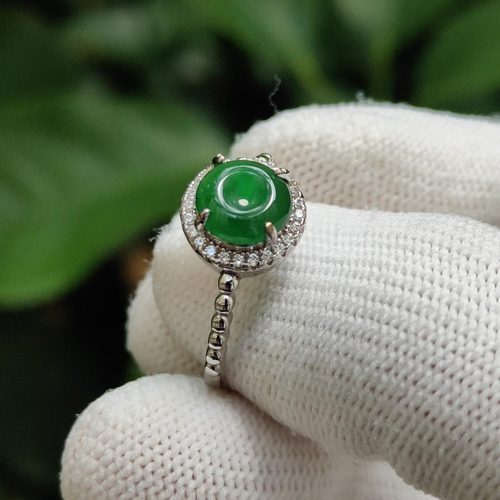 a hand wearing a glove holding a ring